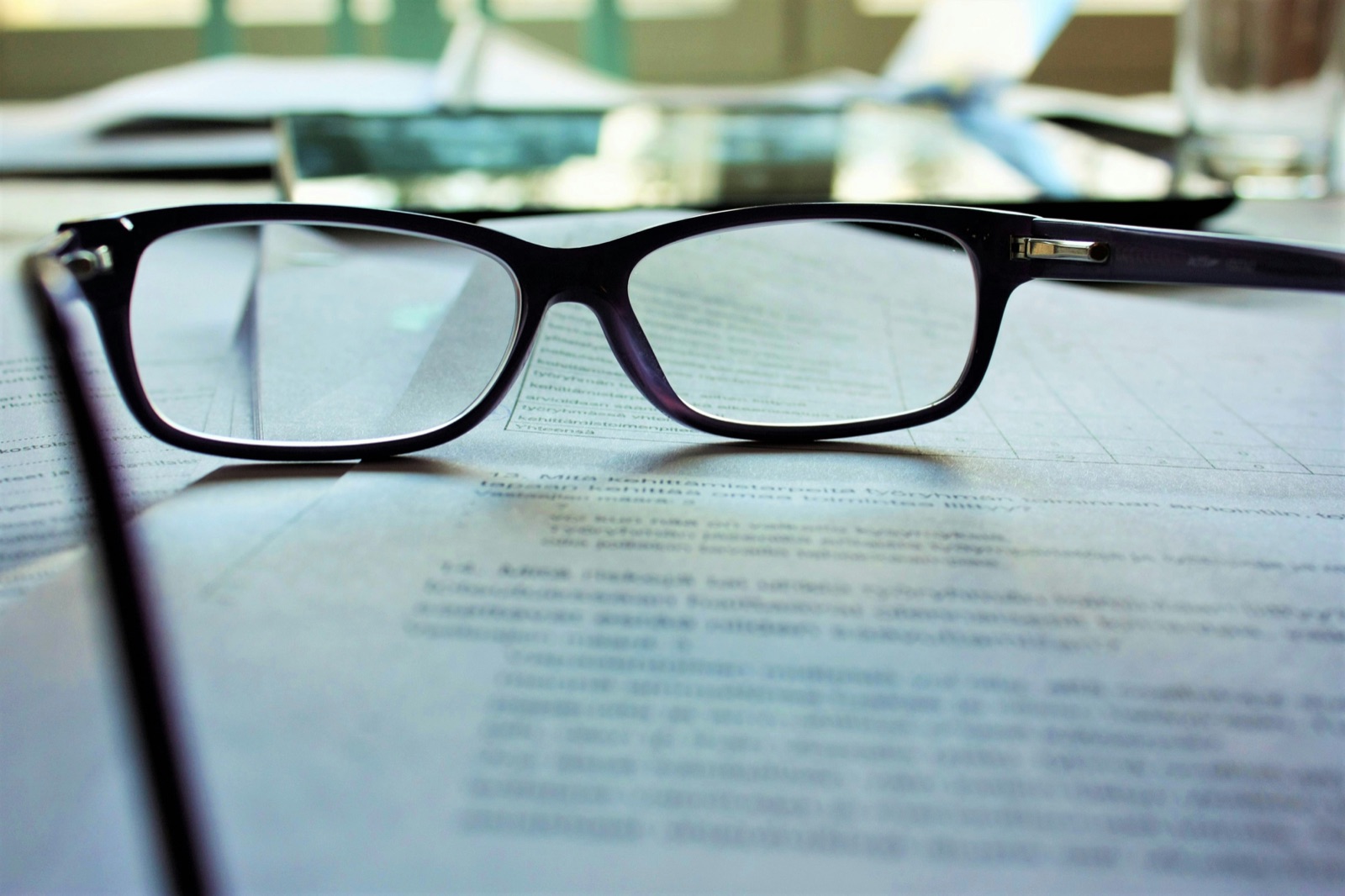 Reading glasses resting on a printed contract