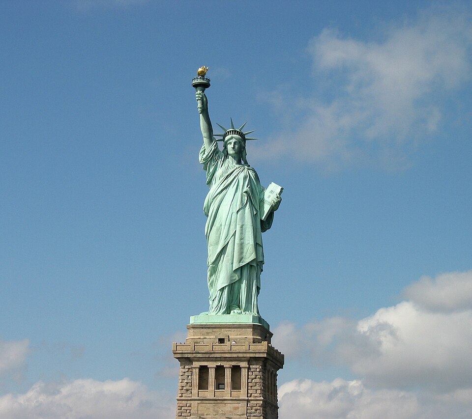 The Statue of Liberty against a blue sky, seen from the ferry